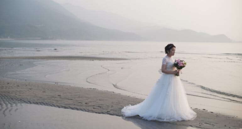浜辺を歩くウェディングドレス姿の花嫁